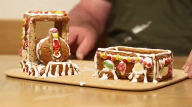 Beyaz krema ve renkli şekerlerle süslenmiş bir zencefilli ekmek treninin detaylı videosu. Geleneksel Noel pişirmelerinin samimi atmosferini yakalıyor.