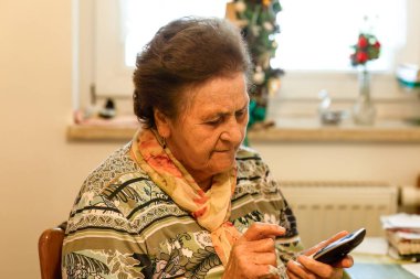 Üst düzey bir kadın telefonundaki bir numarayı çevirirken konsantre oluyor..