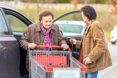 Son sınıftaki bir kadına gezintide kızı alışveriş arabasıyla yardım eder..