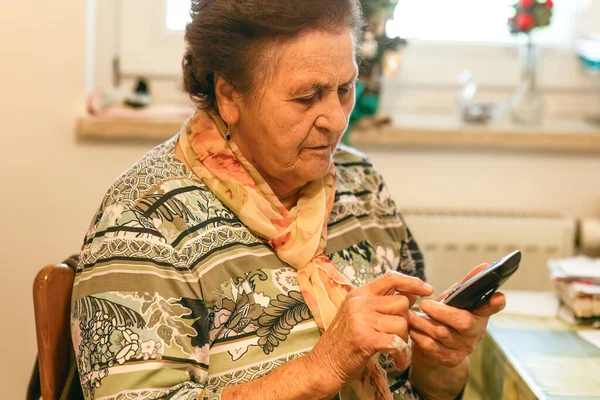 Üst düzey bir kadın telefonundaki bir numarayı çevirirken konsantre oluyor..