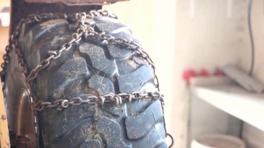 Kışın eklenmiş kar zincirleri ile ağır yükleyici lastiğin kapatılması, soğuk hava koşullarına karşı araç hazırlığı