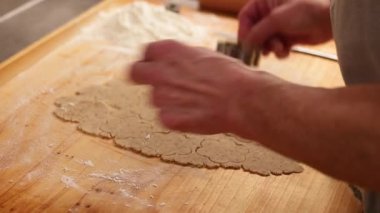 Eller rulo hamurdan kurabiye şekilleri kesiyor. Gerçek Noel hazırlıklarını gösteriyor.