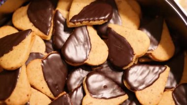 Kalp şeklindeki Noel kurabiyelerinin yarısı çikolata kaplı ve bayram sahnesinde.