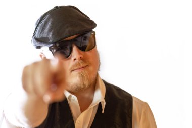 Güneş gözlüklü kendine güvenen adam beyaz arka plandaki izleyiciyi işaret ediyor, doğrudan göz teması, güçlü jest ve kopyalama alanı