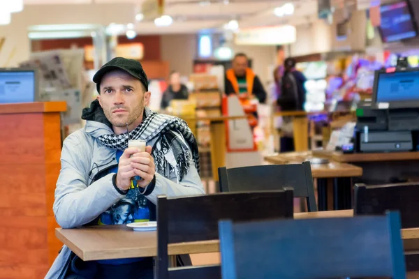 Člověče, pití kávy sedí v Cafe. Důraz je kladen na tvář. Malá hloubka ostrosti. — Stock fotografie