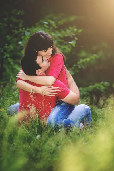 Pareja enamorada de los jóvenes en la naturaleza de las camisas rojas. Tonificación . — Foto de Stock