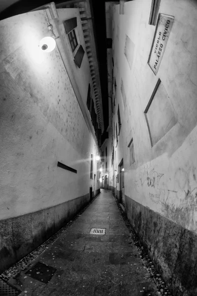 Gece şehir İtalya. Novara. Işıklı Sokağı. Siyah-beyaz fotoğraf. Yumuşak odak — Stok fotoğraf