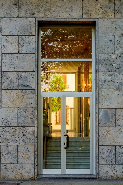 建物にガラスの入り口のドア。ビル暖かな光で入口の近代建築 — ストック写真