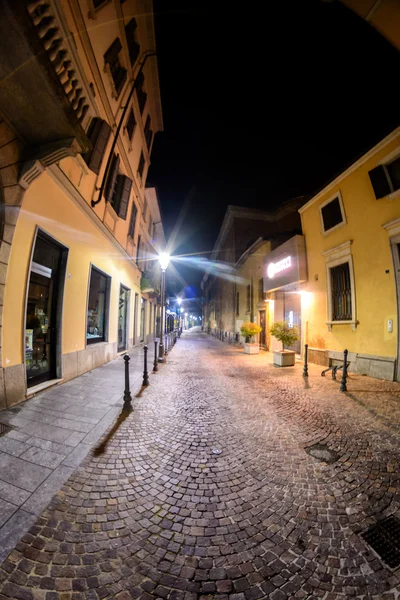 Ciudad nocturna en Italia. Novara. Calle iluminada. Toning. Enfoque suave — Foto de Stock