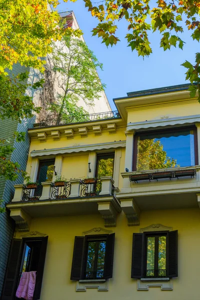 Желтый дом в Италии, на крыше которого растет дерево. Город Новара. Италия . — стоковое фото
