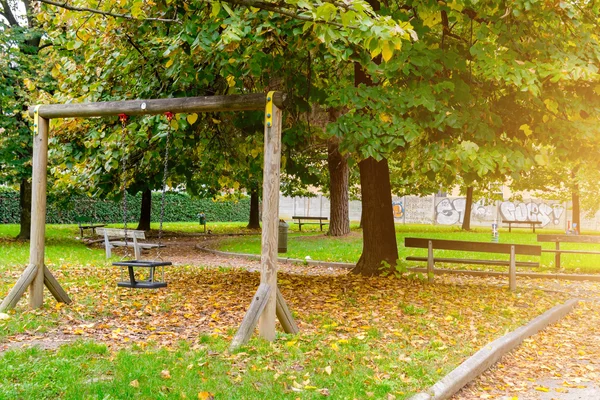 Дитячі дерев'яні гойдалки в осінньому парку. — стокове фото