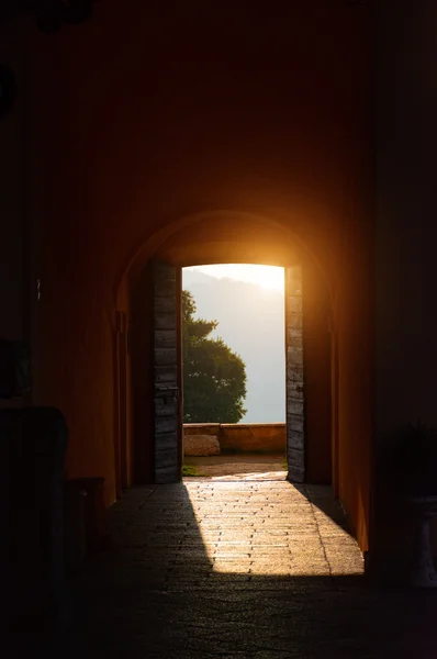 Through the open doors in the sunlight breaks an ancient fortress. Italy, Angera. Castle Rocca di Angera. Toning — Stock Photo, Image