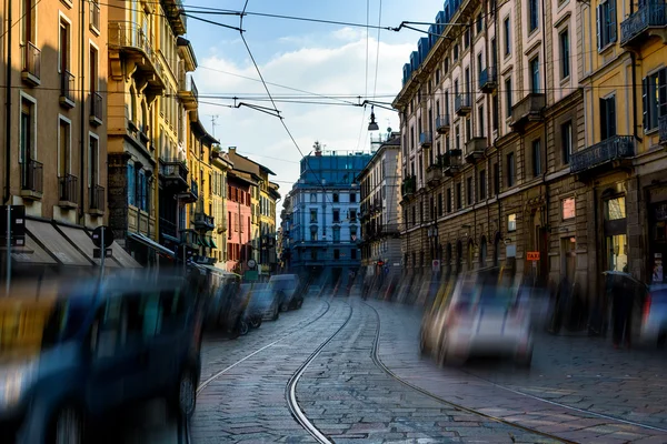 Broad Street com trilhos de bonde entre casas antigas em Milão, Itália. Aplique um movimento de efeito filtro — Fotografia de Stock