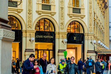 Milan, Italy - October 19th, 2015:Trendy boutique Louis Vuitton in Milan in Duomo cathedral building clipart