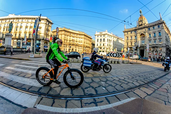 Milão, Itália - 19 de outubro de 2015: Idoso ciclista e policial em uma motocicleta na estrada na rua da cidade Via Cordusio Milão, Lombardia — Fotografia de Stock