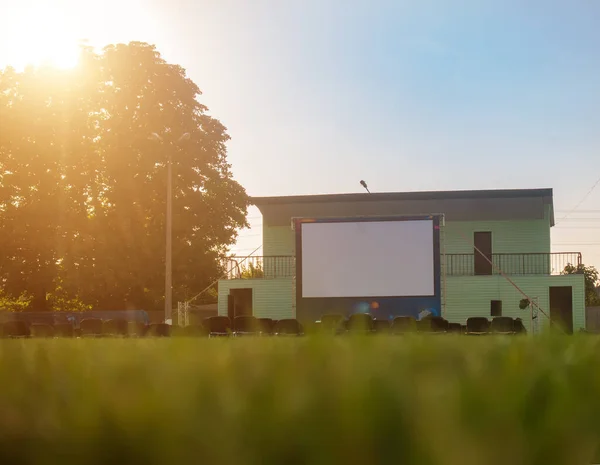 Open-air cinema on a green lawn.