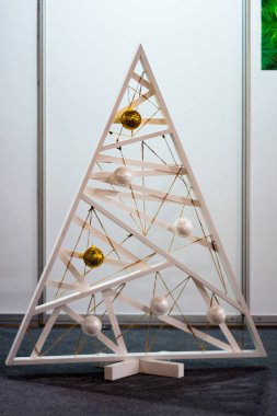 Yuvarlak oyuncaklarla ahşaptan yapılmış orijinal üçgen ağaç.