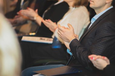 İnsanlar sırada otururken alkışlıyorlar..