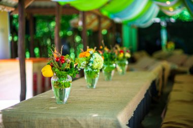 Yemek masasında bir buket yabani çiçek ve sebze..