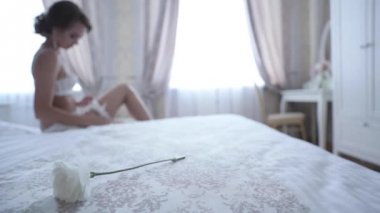 Güzel kız seksi iç çamaşırı yatak odasında giyiniyor.
