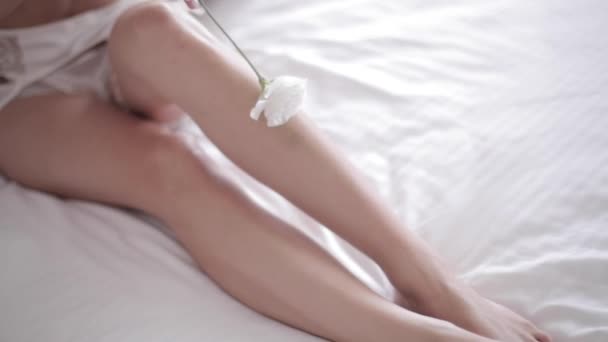 Schöne Mädchen in Unterwäsche liegen im Bett mit Blume — Stockvideo