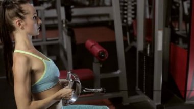Güçlü genç esmer kadın spor salonunda eğitim.