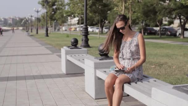 Mujer joven con tableta en el parque — Vídeo de stock