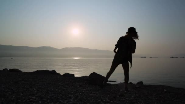 Silhouette d'une adolescente dansante au lever du soleil — Video