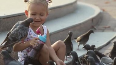 Küçük şirin kız güvercin çeşme beslenir.