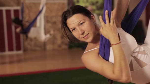 Anti-zwaartekracht Yoga, vrouw doen yoga oefeningen binnen — Stockvideo