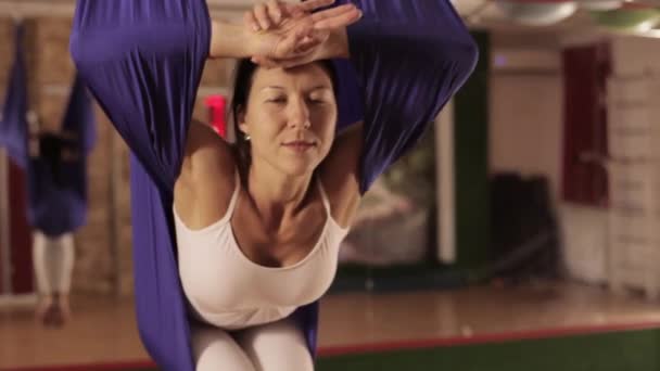 Anti-zwaartekracht Yoga, vrouw doen yoga oefeningen binnen — Stockvideo