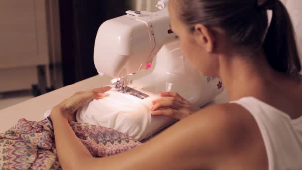 Young woman sews on the sewing machine — Stock Video