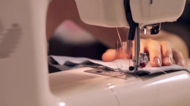 Dikiş dikiş makinesi üzerinde bir kadının görüntüleri kapat