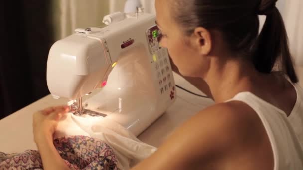 Young woman sews on the sewing machine — Stock Video