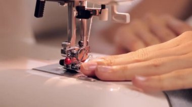 Dikiş dikiş makinesi üzerinde bir kadının görüntüleri kapat