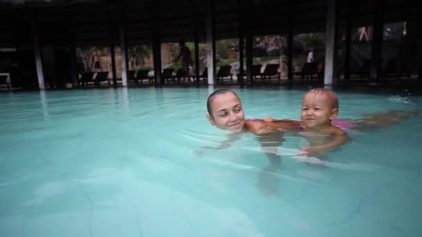 Madre divirtiéndose con la niña en la piscina . — Vídeos de Stock