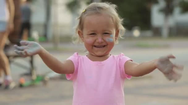 可爱的小女孩用粉笔，弄脏了乐趣和显示她对着摄像机的脏手 — 图库视频影像