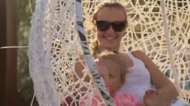 Anne ve küçük kızı salıncakta eğleniyor