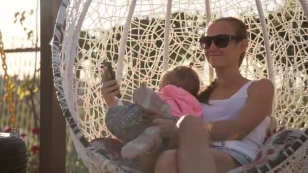 Mutter und kleine Tochter haben Spaß auf der Schaukel — Stockvideo