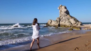 Genç ve çekici bir kadın sahilde yalnız yürüyor..