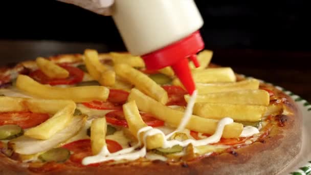 Крупный план заливки белого соуса в готовую пиццу с картошкой фри — стоковое видео