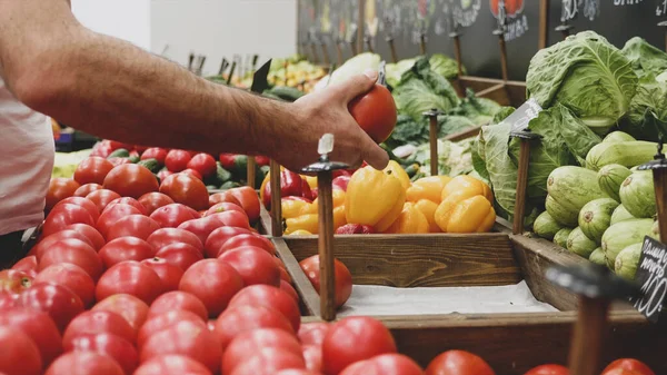 Primer plano manos de trabajador de comestibles está organizando verduras en estantes de la tienda Fotos De Stock Sin Royalties Gratis