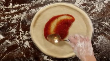 Pizza hamuruna domates sosu koymaya yakın çekim