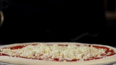 Peynir pizzanın üstüne düşüyor, yavaş çekimde yakın çekim..