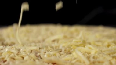 Peynir pizzanın üstüne düşüyor, yavaş çekimde yakın çekim..