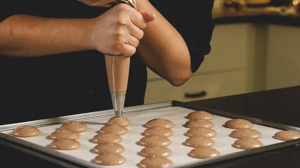 Cuoco che fa la base per dessert di macaron di preparazione. Fotografia Stock