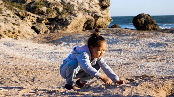 Счастливая маленькая девочка, наслаждающаяся летним отпуском и играющая на пляже. Стоковая Картинка