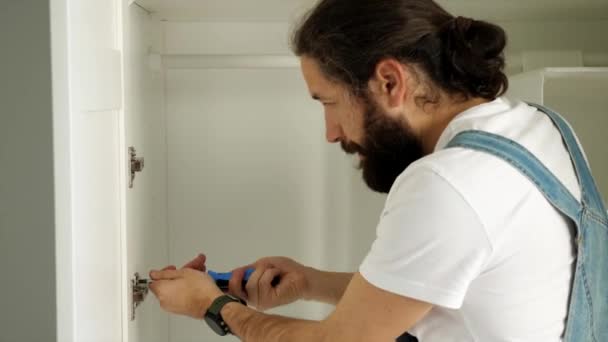Mężczyzna instaluje drzwi na szafie. — Wideo stockowe