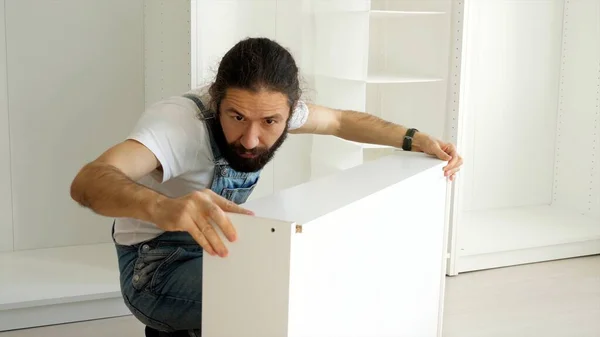 Un uomo sta assemblando il cassetto per l'armadio Foto Stock Royalty Free