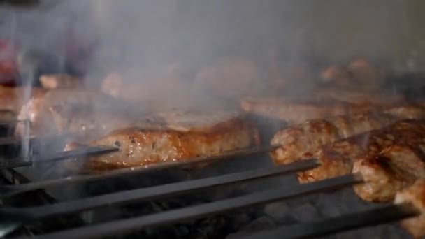 Há cozinheira de carne com espetos sobre carvão vegetal. — Vídeo de Stock